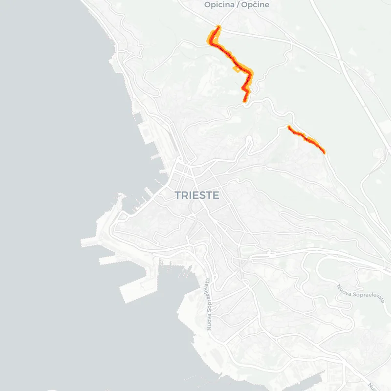 Noise map of Trieste, Italy: road-traffic noise contours from the EU strategic noise maps, shaded yellow (≈55 dB Lden) through orange and red to dark purple (≈75 dB+), over the city's street network.